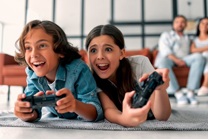 Young brother and sister playing video games in kid’s game room