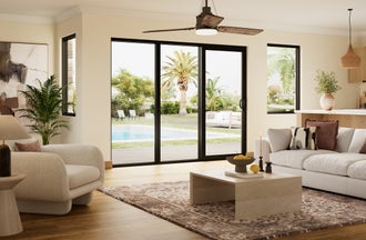 Bronze sliding patio door in a cozy living room with a pool in the background