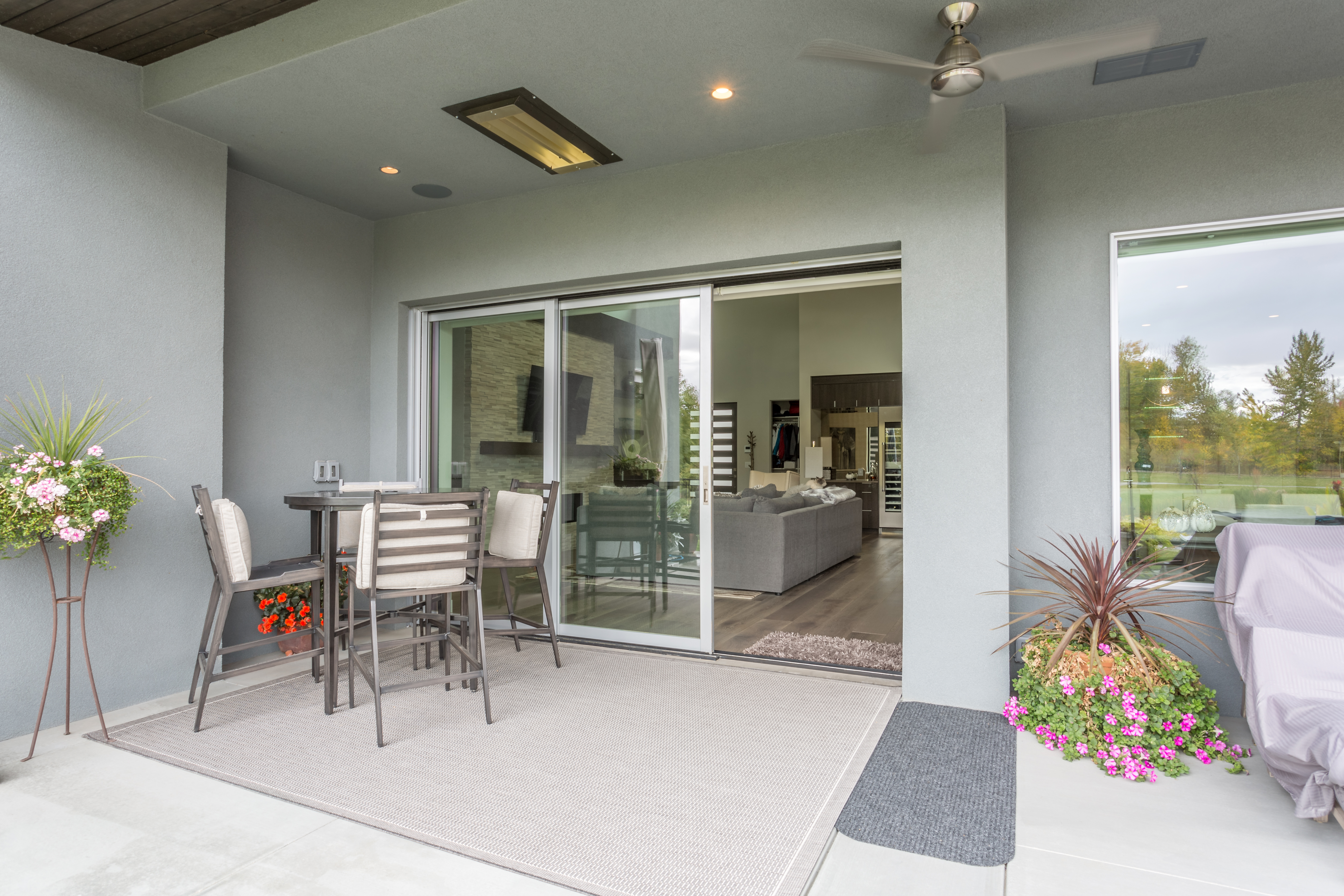 A covered porch with a multi-slide patio door connecting to a living room 