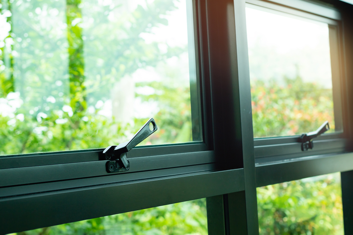 A closeup of double-hung windows. The aluminum window frame material is lightweight but liable to oxidize.