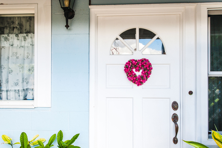 Valentine’s Day door décor in the form of a small heart-shaped wreath in shades of pink.