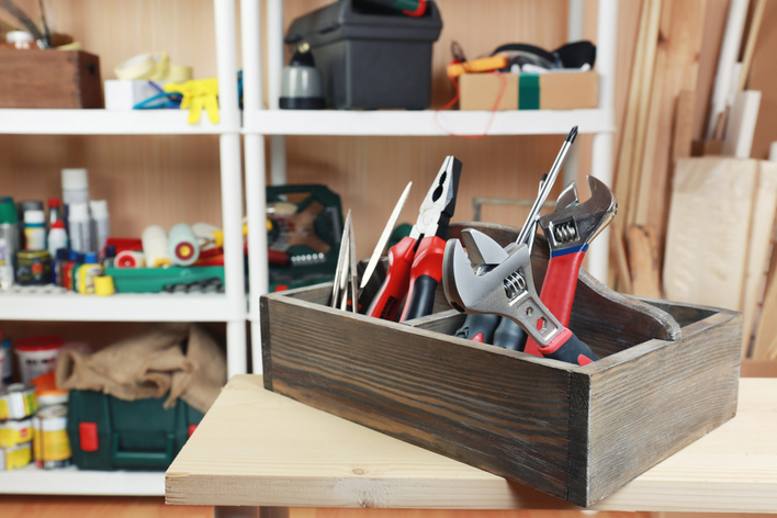 A wooden toolbox with wrenches in a garage workshop