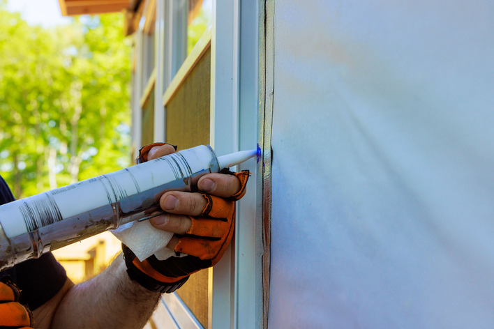 Window World worker carefully installing a window on a house.