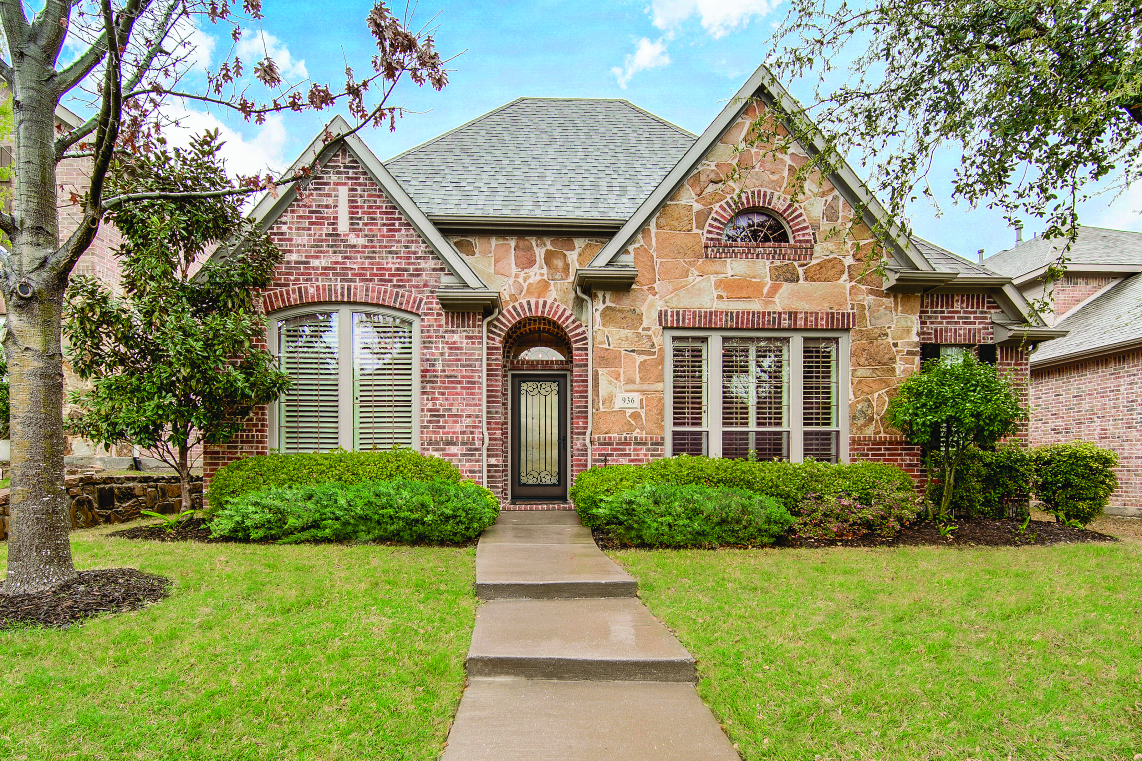 A Driftwood colored Classic Craft Entry Door on a house built from brick and stone