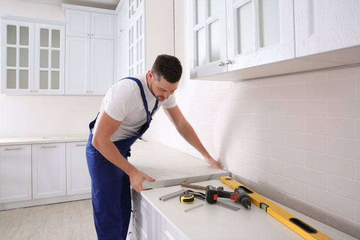 A man installing a kitchen counter as a home improvement project