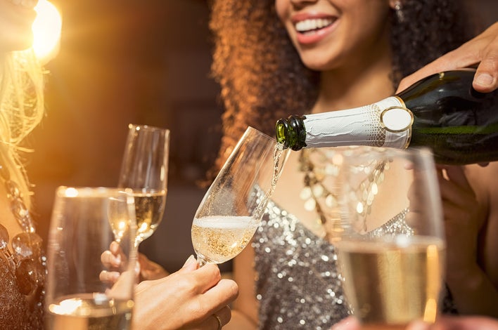 Close up photo of pouring champagne into a champagne flute glass for New Year’s Eve