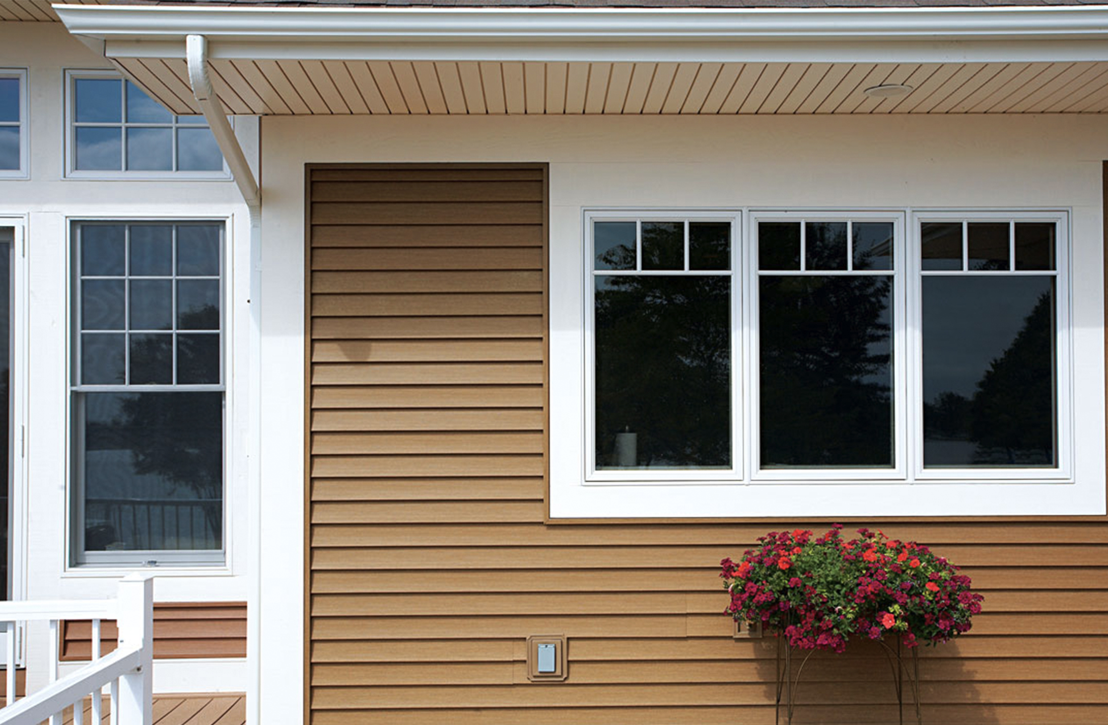 A house with brown siding with white gutters.