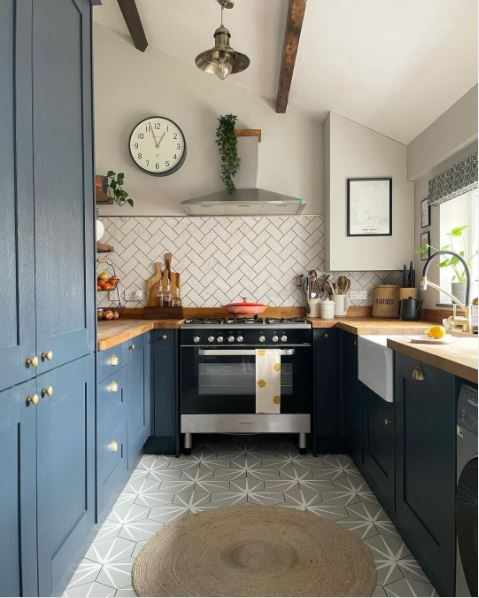 A rustic kitchen with blue cabinets and grey walls