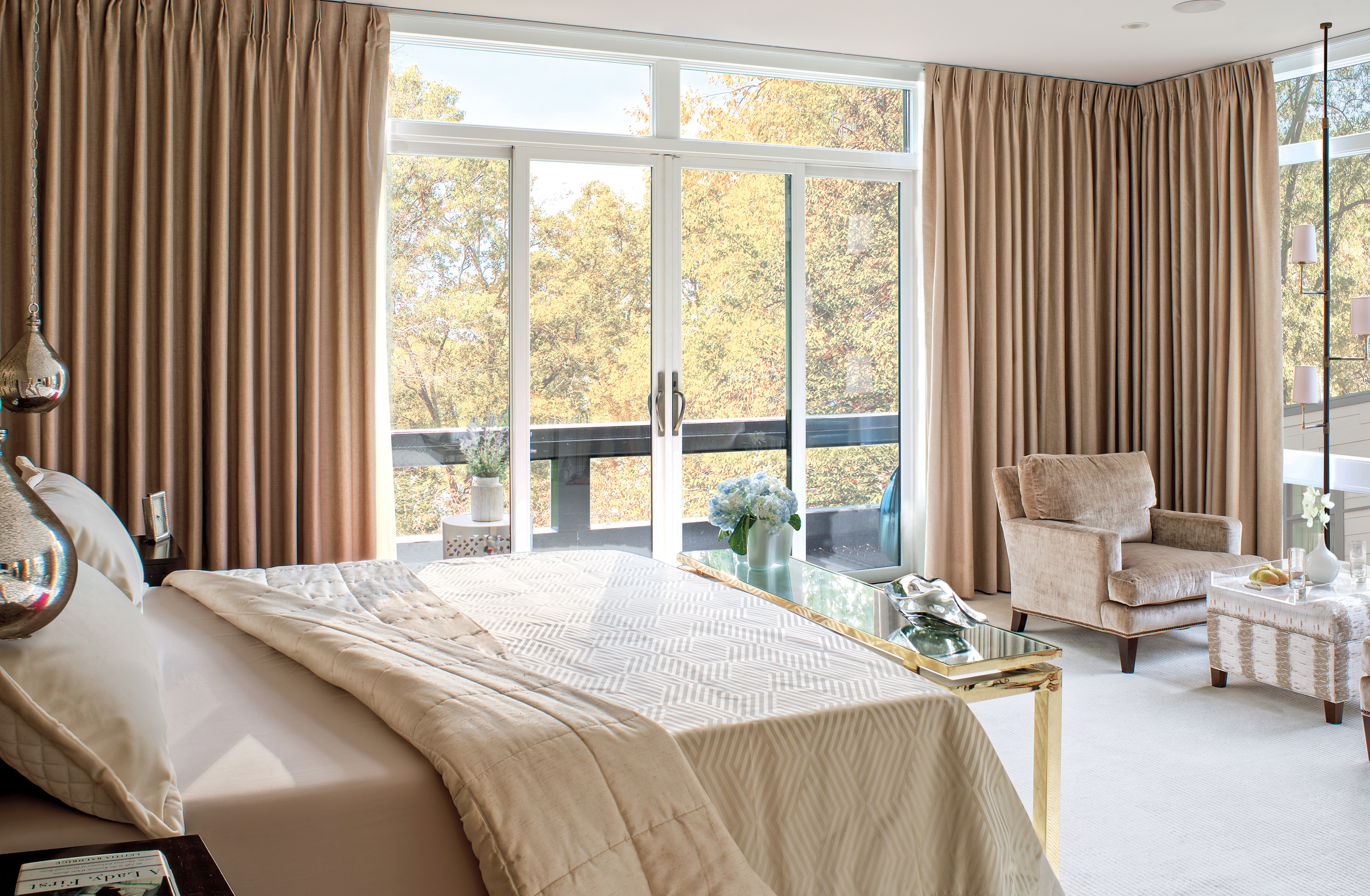 A bedroom with floor to ceiling curtains with a white bi-parting sliding patio door.
