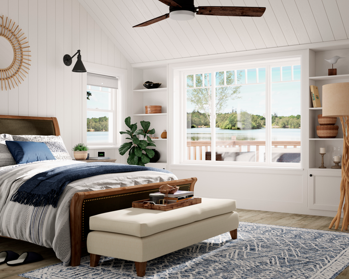 White-framed windows allow sunlight into a blue-accented bedroom.