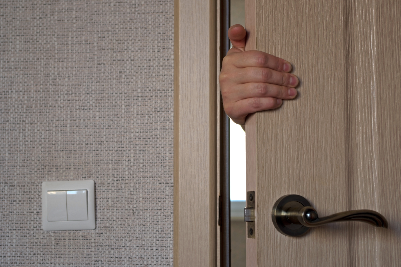 hand opening an interior door inside of a house hand opening an interior door inside of a house