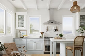 Casement windows in a spacious kitchen with the ocean in the background of the windows