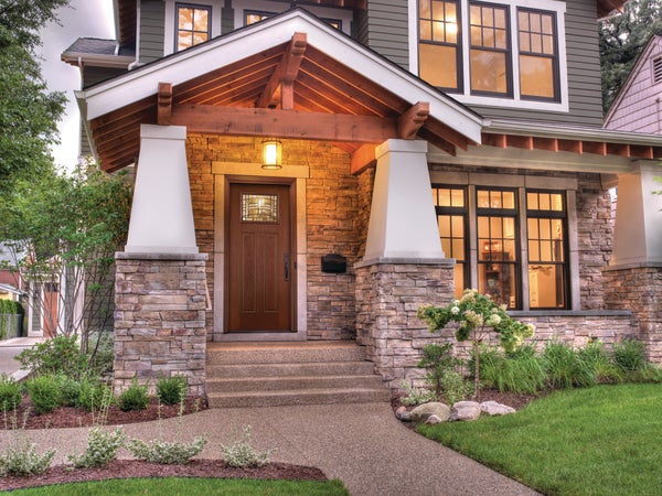 A Fiber-Classic® Fiberglass Entry Door on a 2 story house with a stone driveway