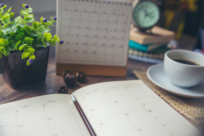 A calendar and planner on a table that are being used to plan the beginning of a home remodeling project