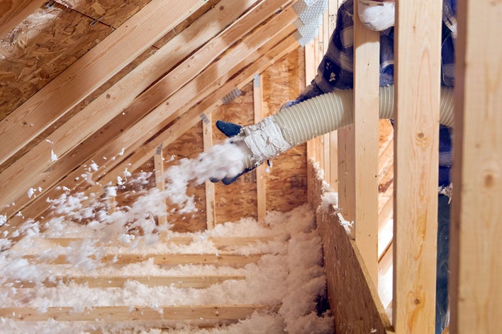 Worker replacing home insulation as a way to reduce noise pollution at home.