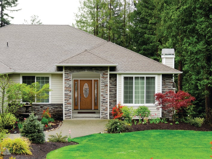 The front view of a well-maintained home, including its energy-efficient front door The front view of a well-maintained home, including its energy-efficient front door