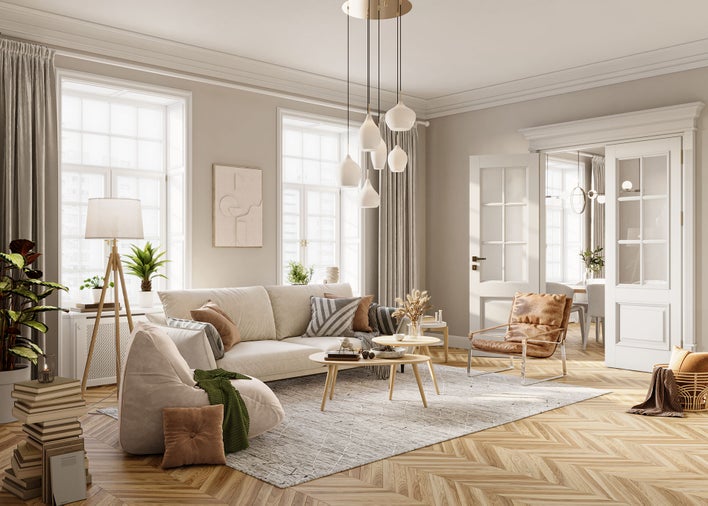 A beautiful living room with earth-tone decorations that are naturally illuminated by large windows and hinged patio doors.