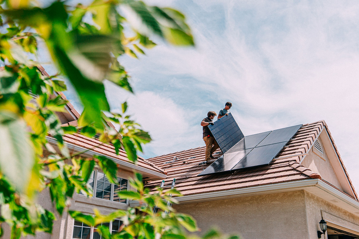 Sustainable home remodeling ideas include solar panels like those being installed on this roof.