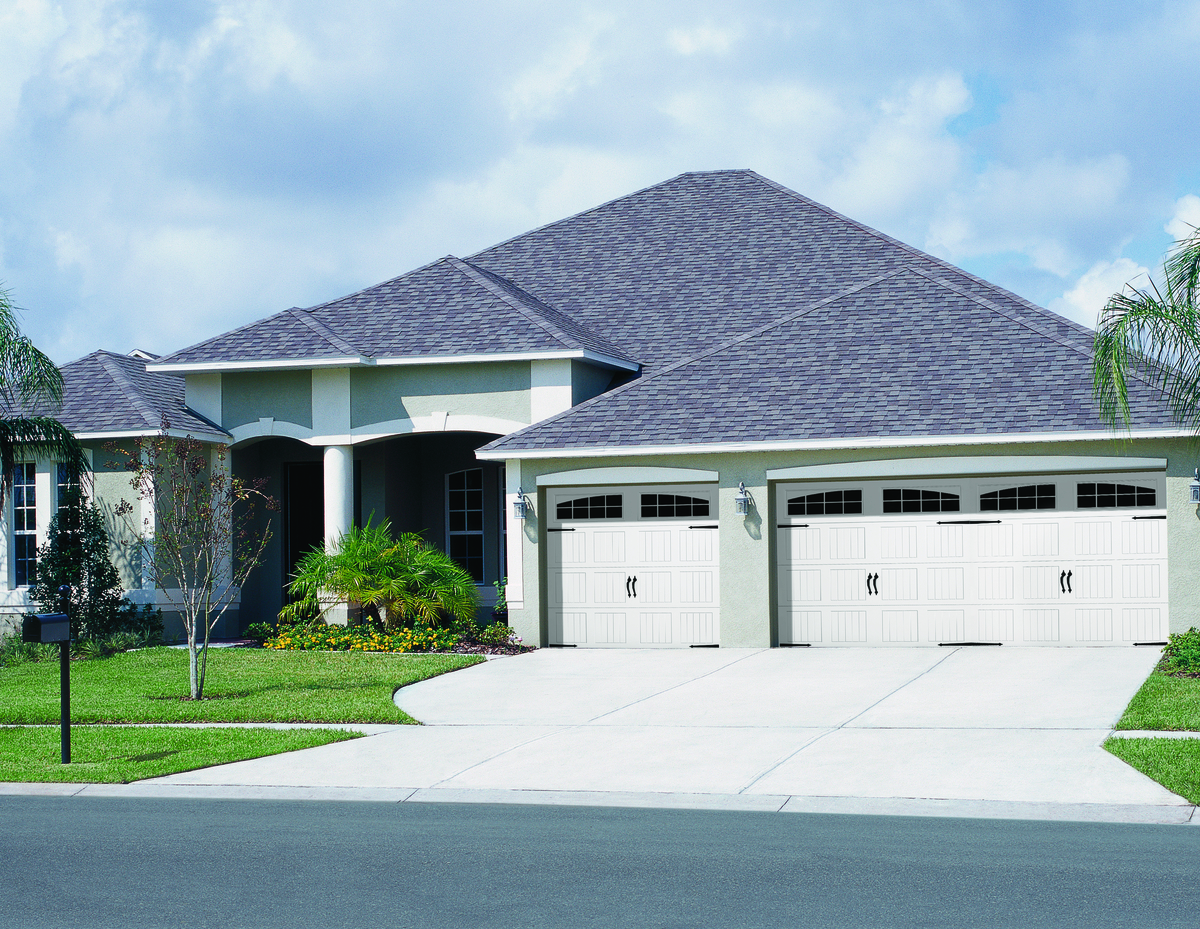 White vertical short panel  garage door with arch stockton windows and decorative hardware