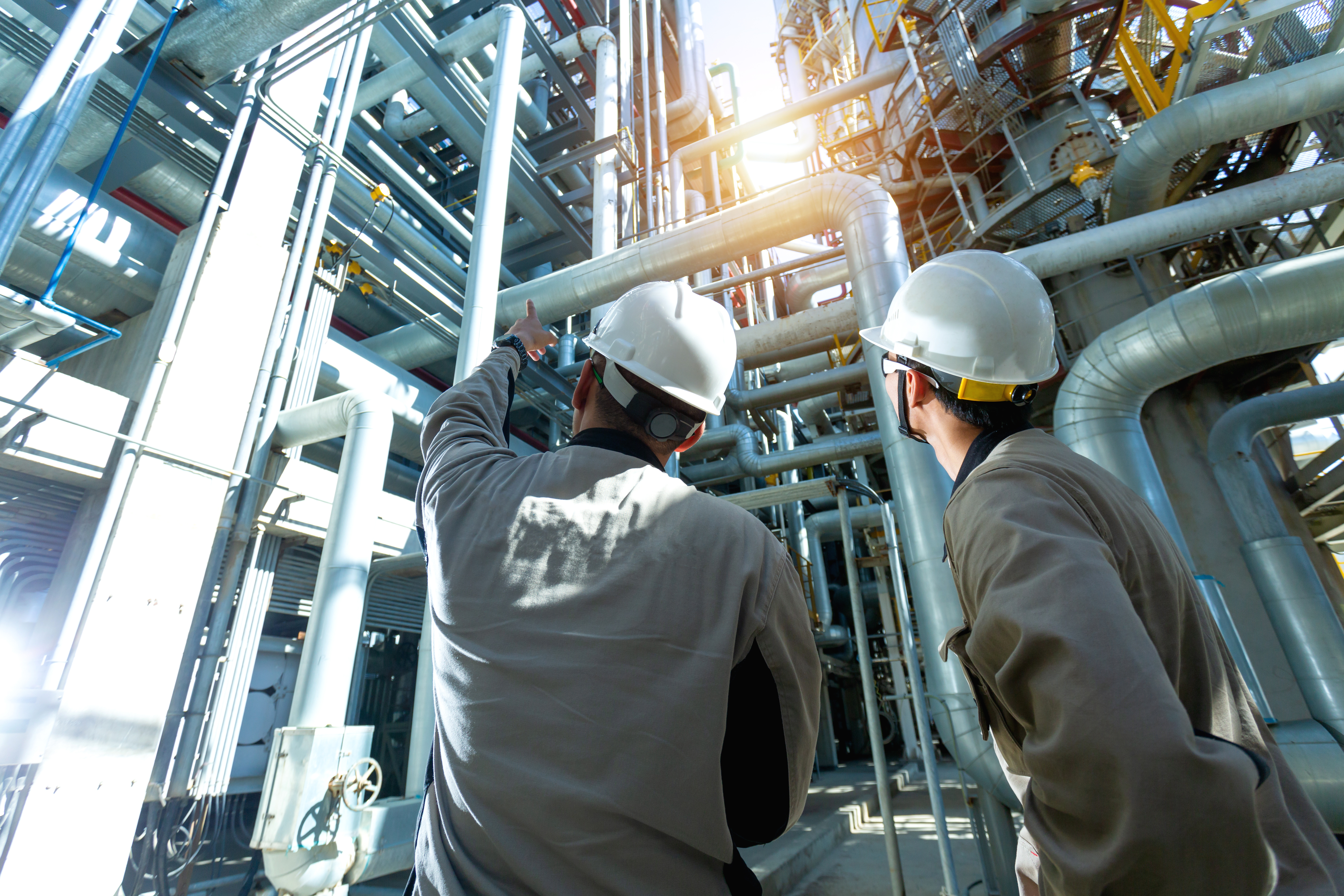 industrial workers looking at piping