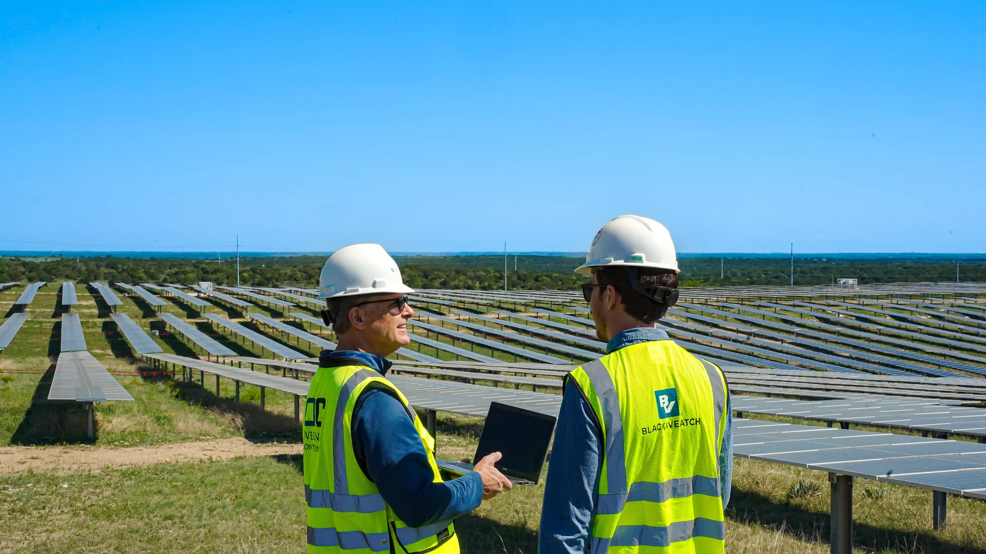 Two construction workers in field of solar panels