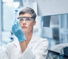 Woman works in a pharmaceuticals labor under controlled environments