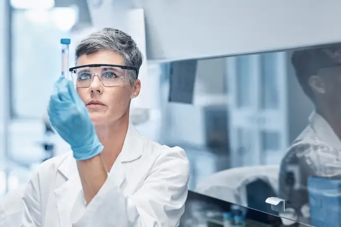 Woman works in a pharmaceuticals labor under controlled environments