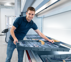 Man works on the Shuttle XP equipped with Kardex VLM Boxes