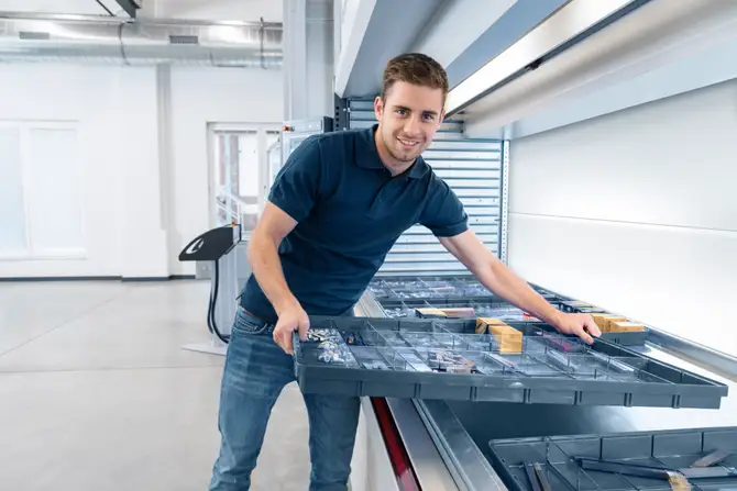 Man works on the Shuttle XP equipped with Kardex VLM Boxes
