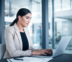 A woman sitting in front of a laptop in an office