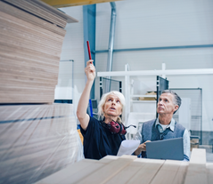 Two people in a warehouse for wood and furniture