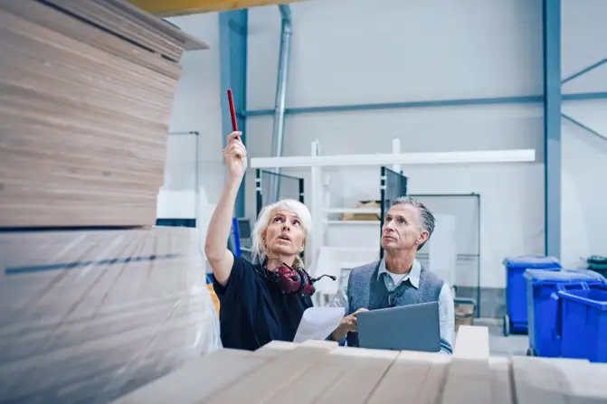 Two people in a warehouse for wood and furniture