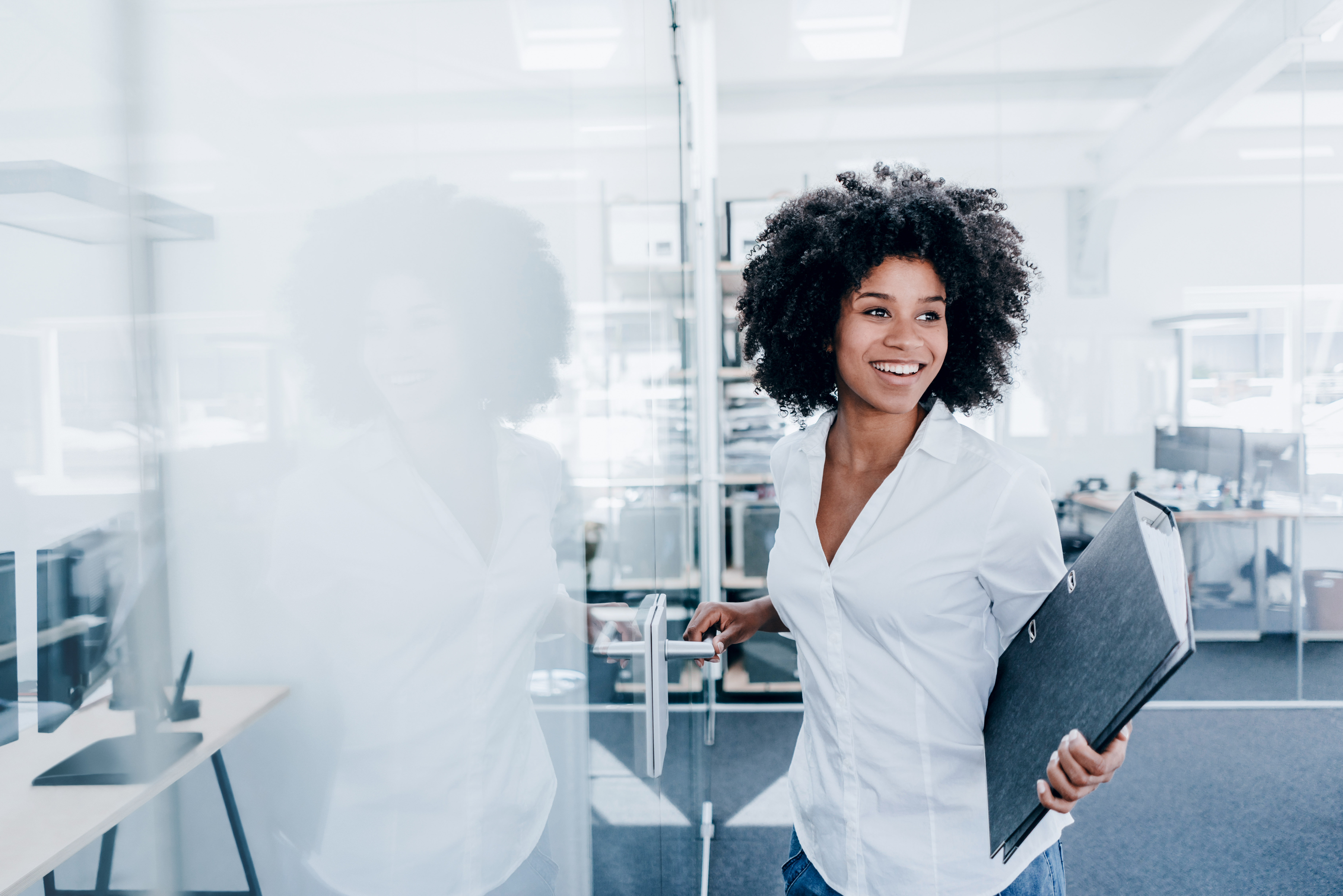 Woman in an office with folder in hand