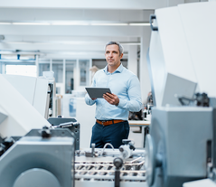 Software expert standing next to a conveyor system with a tablet