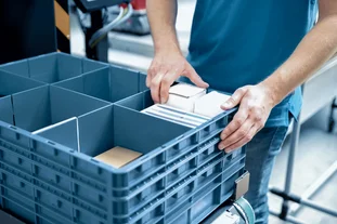 Man storing small parts in a Kardex VBM Box