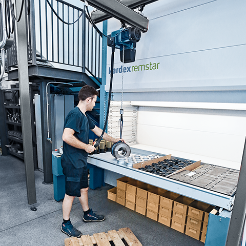 Un homme utilisant un palan intégré avec un Vertical Lift Module pour stocker et prélever des outils