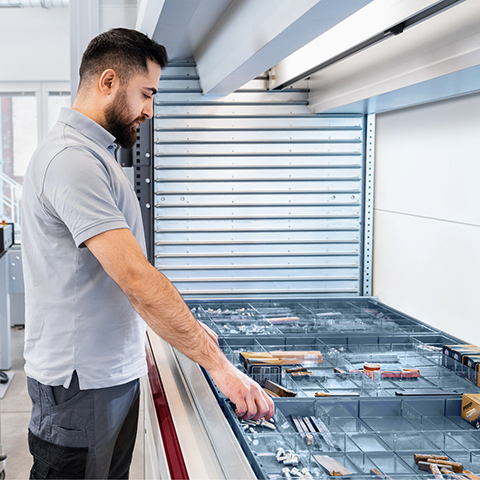 Ein Mann arbeitet am Kardex Shuttle mit Kardex VLM Boxen