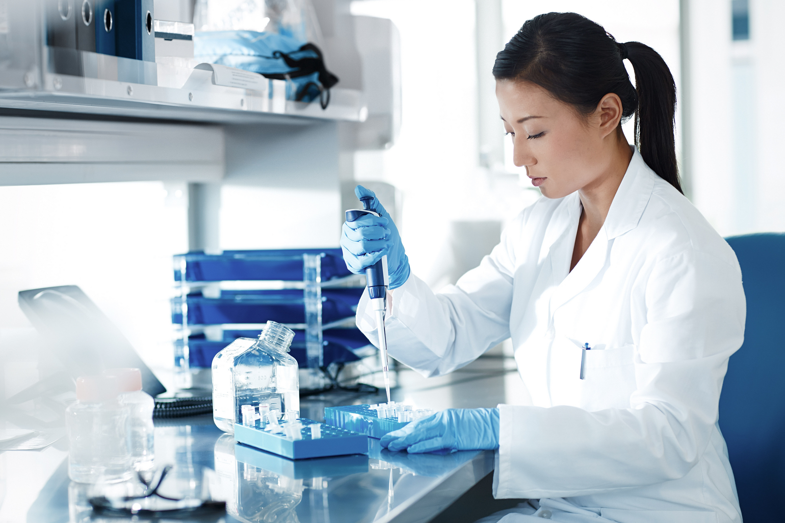 Woman works in a pharmaceuticals labor under controlled environments