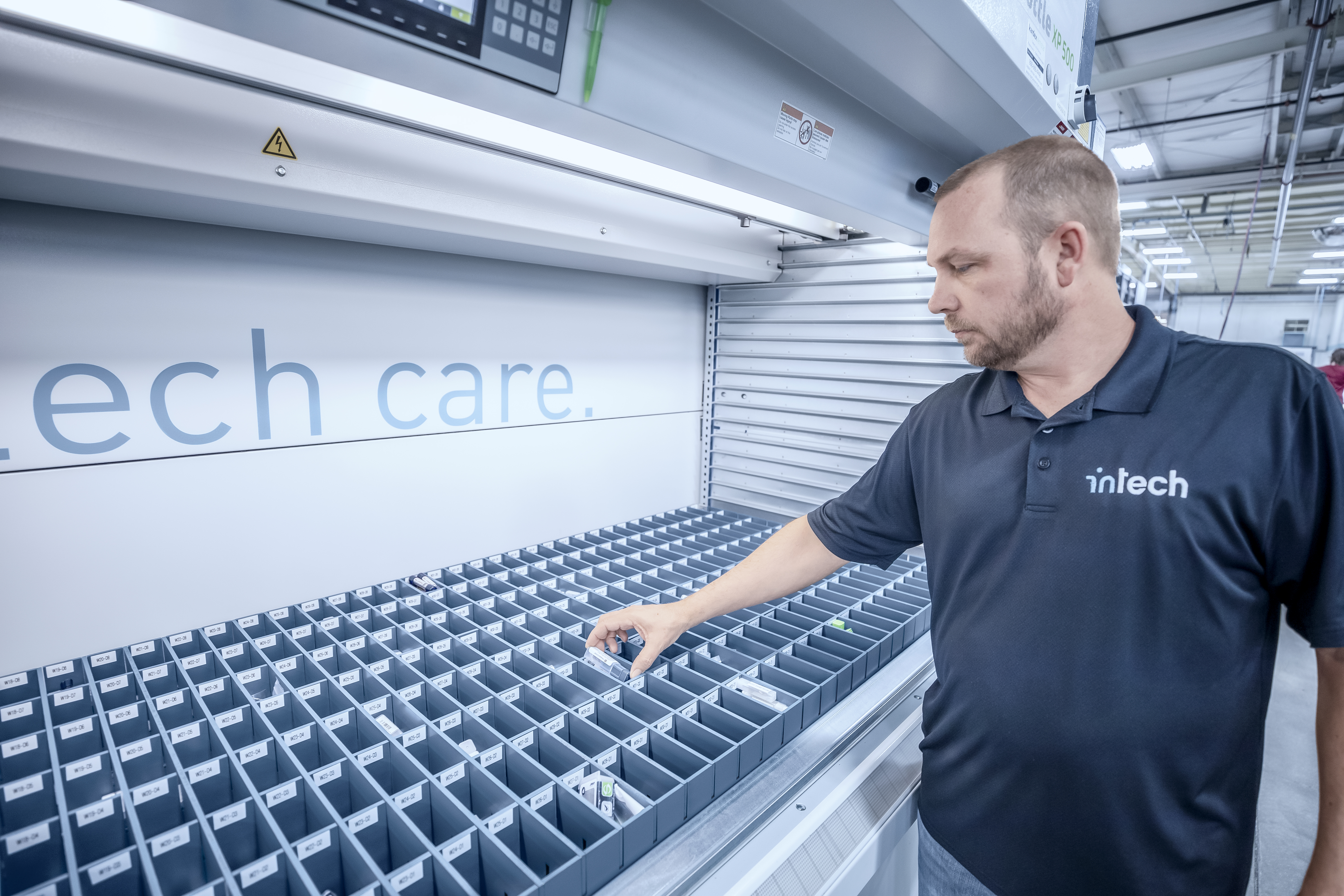 man picking medical device parts from Kardex shuttle