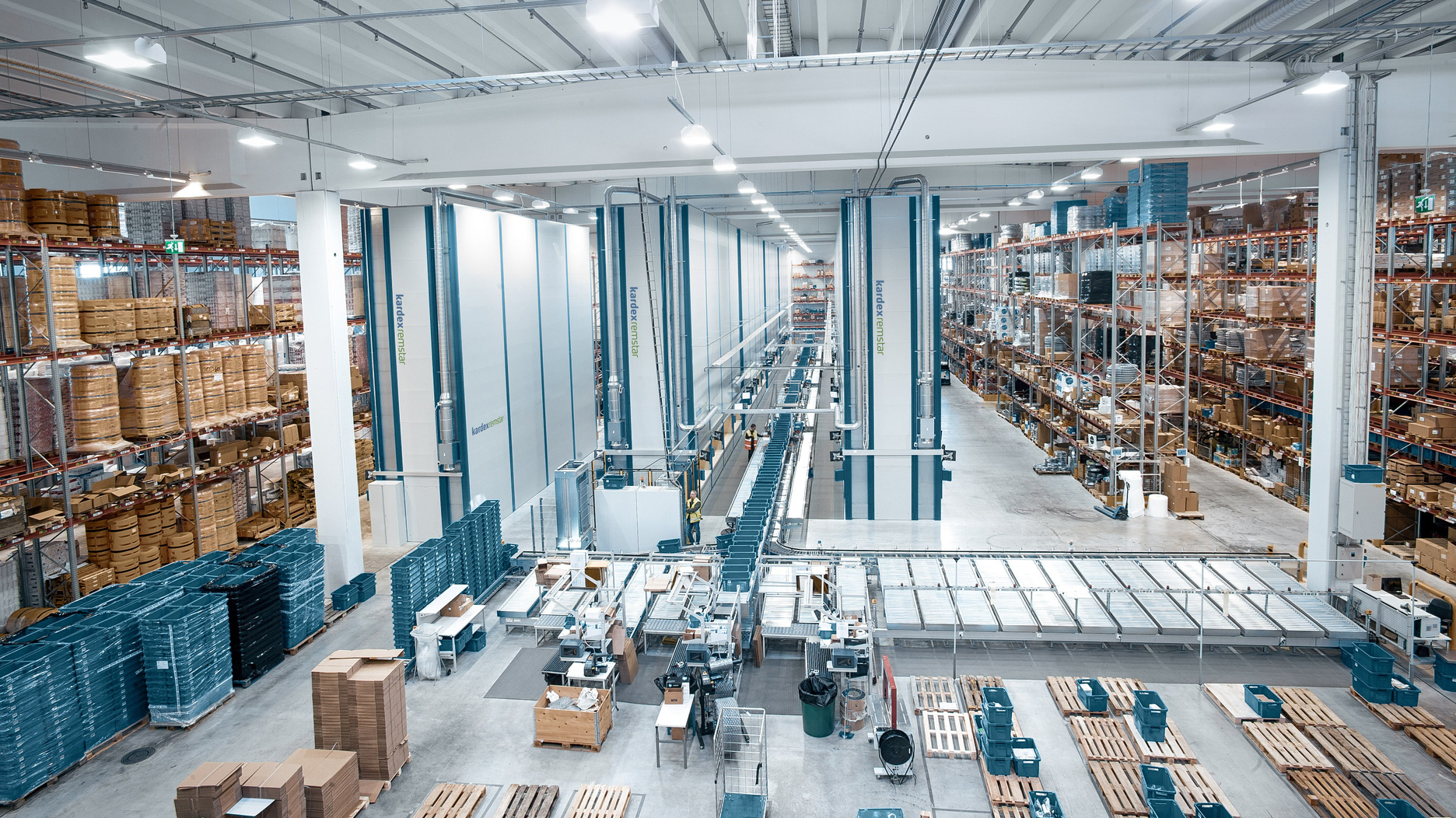 Distribution center with storage in static shelves, on pallets and in vertical lift systems