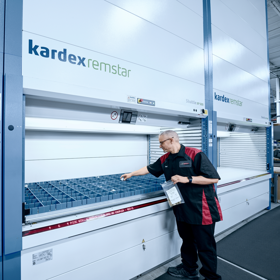 Man haalt artikelen uit de Kardex Miniload-in-a-Box (voorheen Kardex Compact Buffer) met Kardex VBM Boxes