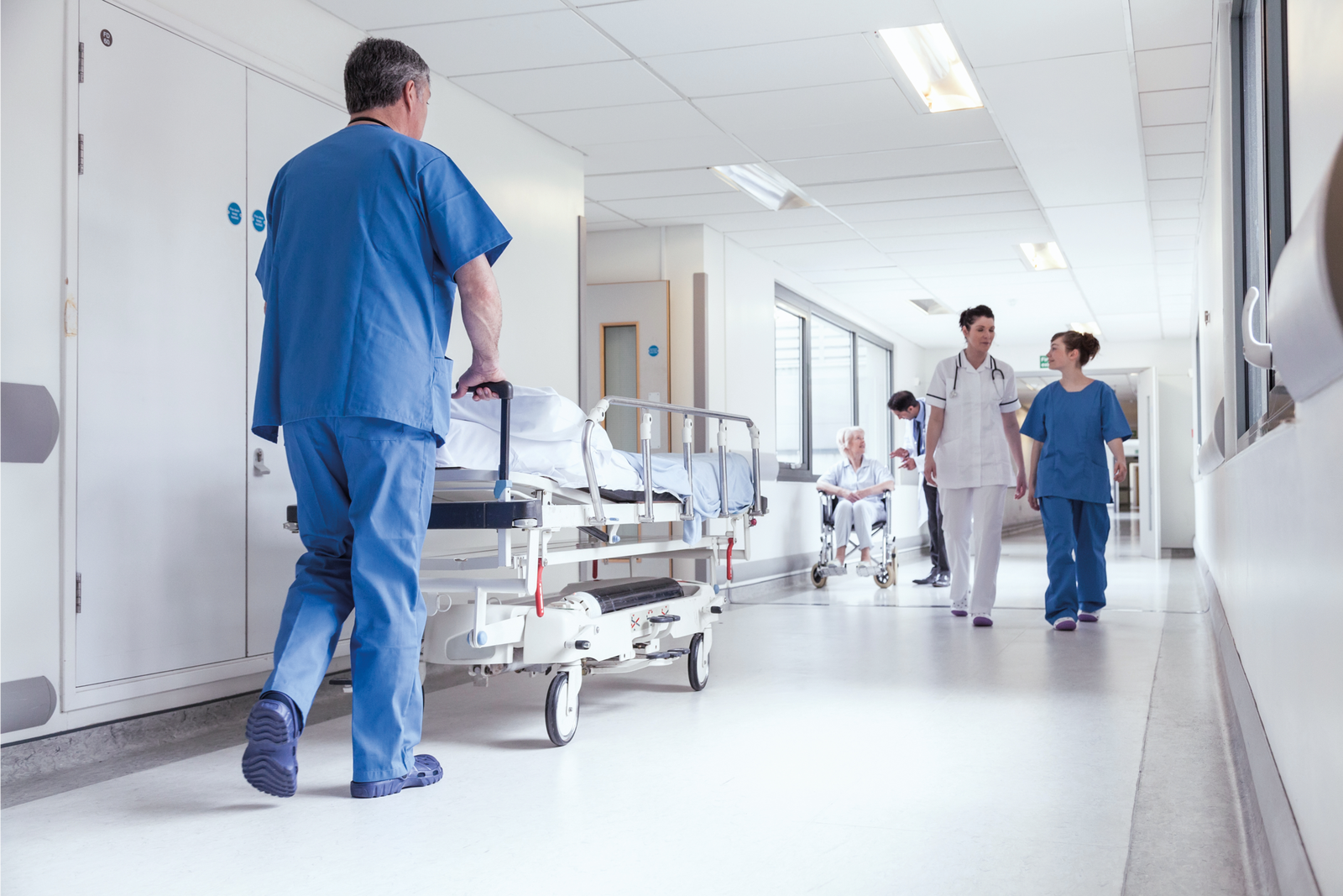 Uomo che spinge il letto in un ospedale