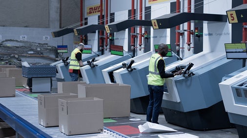Man standing in front of containers and planning their shipping