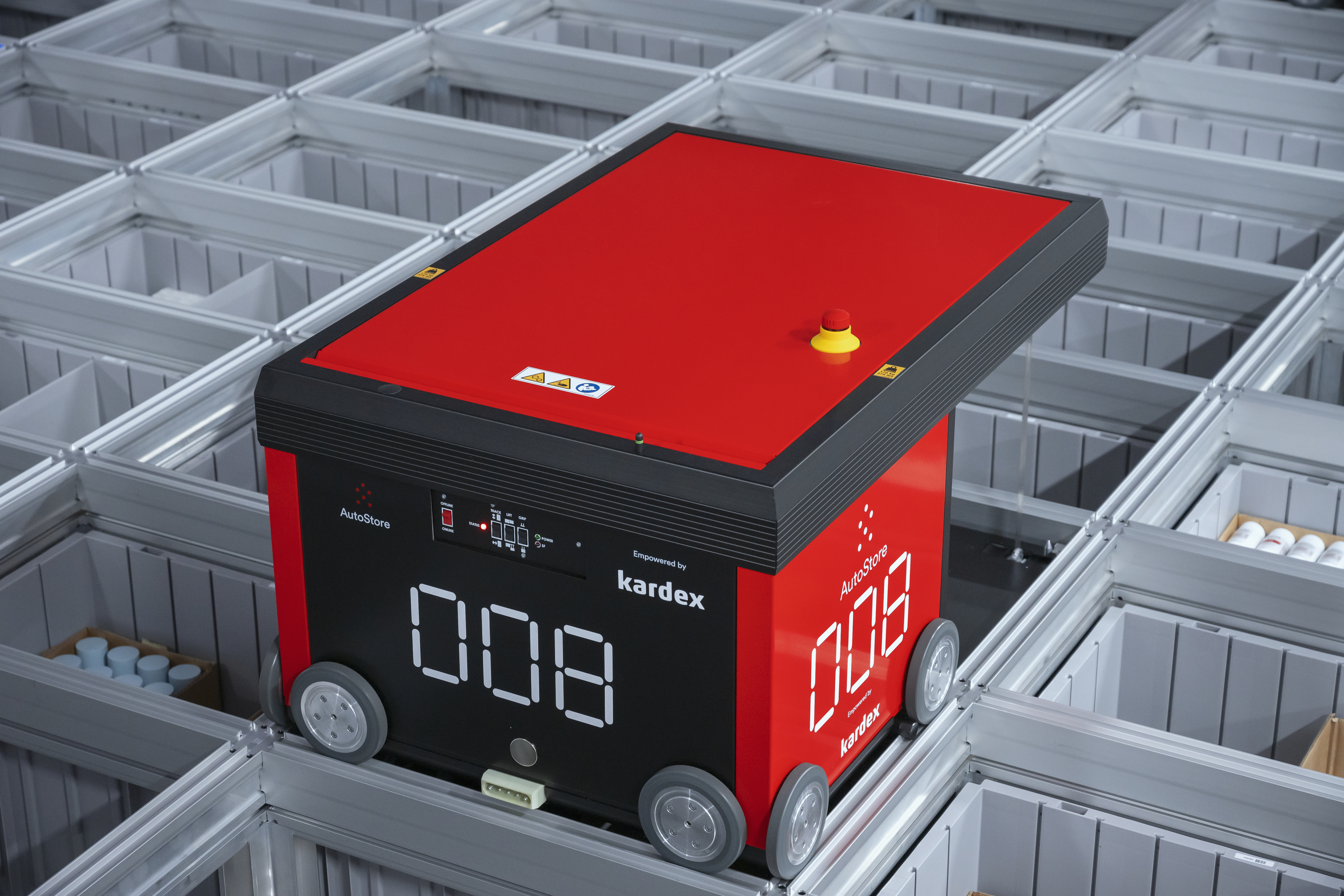 Red square robot with wheels on metal grid