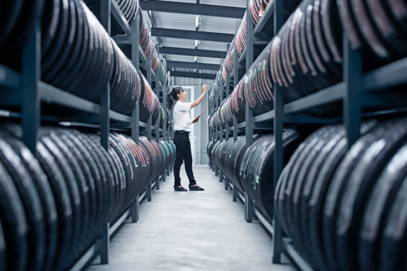 Lady counting tyres in a tyre warehouse