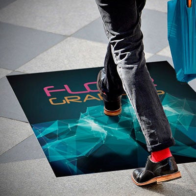 A person walking on a graphic floor sticker with a modern, geometric design