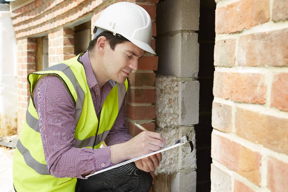 A professional insulation installer assessing a Milwaukee home, emphasizing the importance of choosing experienced contractors