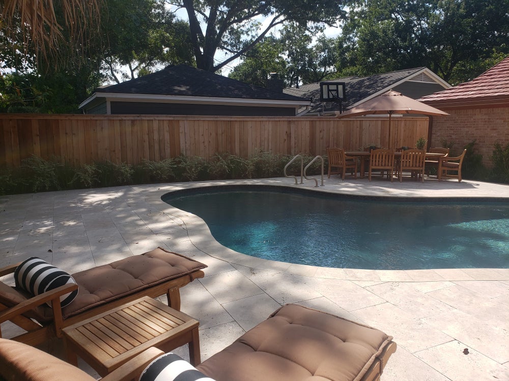 A beautifully designed outdoor living space in a Pearland backyard, showcasing comfortable seating and stylish decor