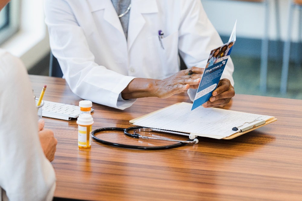 Healthcare professional showing services brochure to patient in clinic