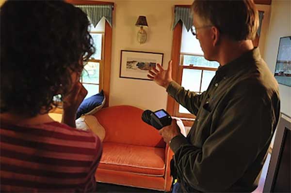 A certified insulation professional assessing a home's insulation needs and discussing solutions with the homeowner